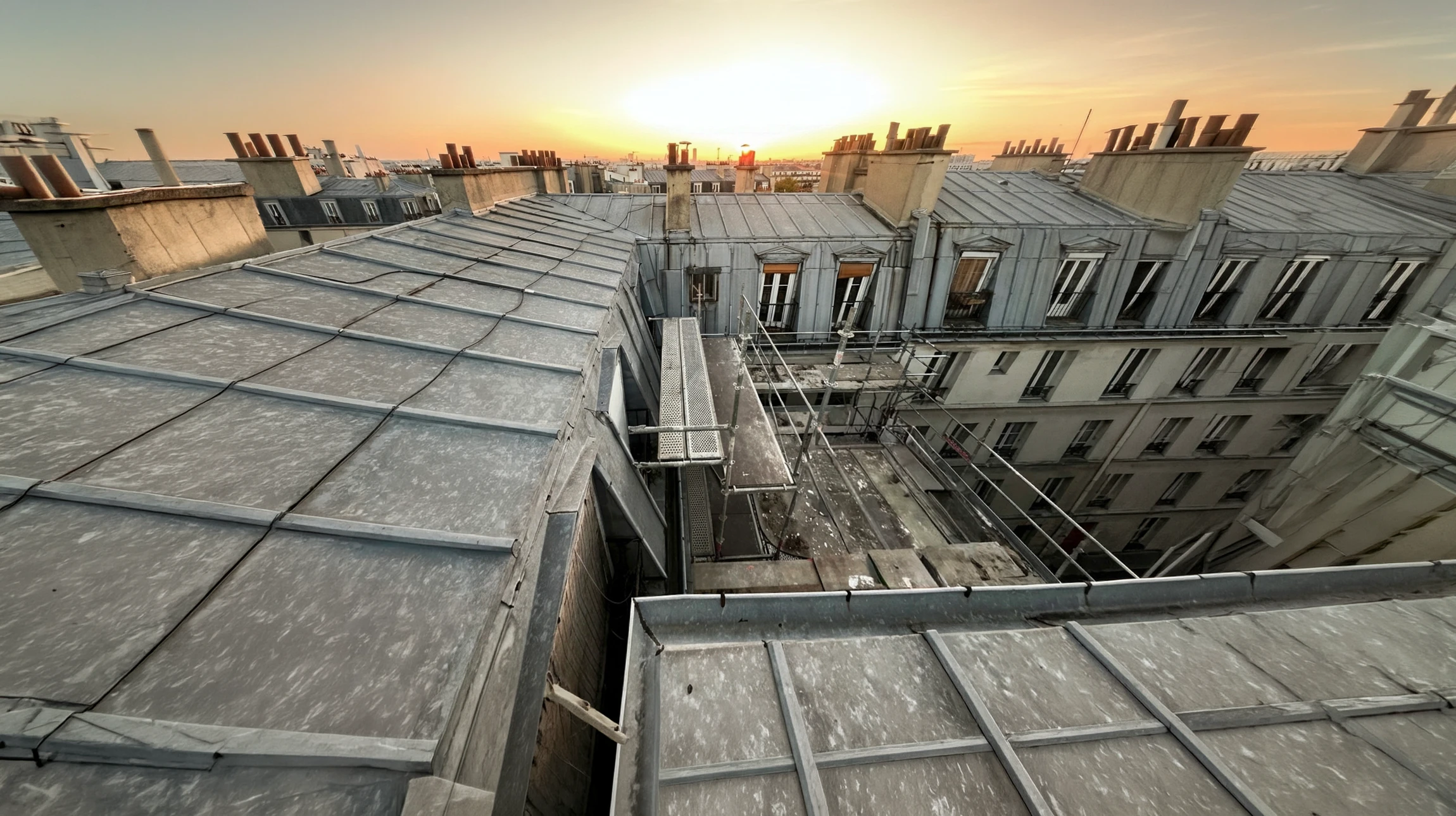 Ext&eacute;rieur, vue en contre-plong&eacute;e d'une toiture pyramidale en ardoises avec charpente apparente et girouette d&eacute;corative au sommet