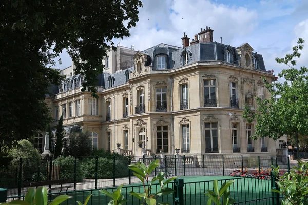 Photographie professionnelle d'un immeuble parisien classique de style Haussmannien situ&eacute; &agrave; Boulogne-Billancourt, prise de face au niveau de la rue, montrant la fa&ccedil;ade &eacute;l&eacute;gante avec ses fen&ecirc;tres typiques, ses balcons en fer forg&eacute; et sa toiture en ardoise/zinc visible en arri&egrave;re-plan. L'image doit capturer l'architecture caract&eacute;ristique des immeubles bourgeois de cette commune francilienne, illustrant le type de b&acirc;timents sur lesquels ICR Couverture intervient.