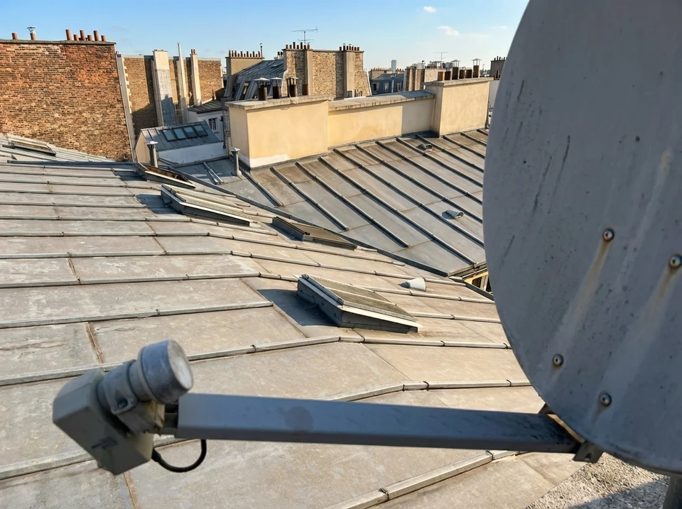 Scène extérieure résidentielle avec numéro d'adresse 12 sur plaque céramique décorative fixée à une grille métallique rouillée